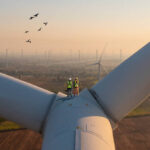 Two rope access technicians working on higher wind turbine blades.